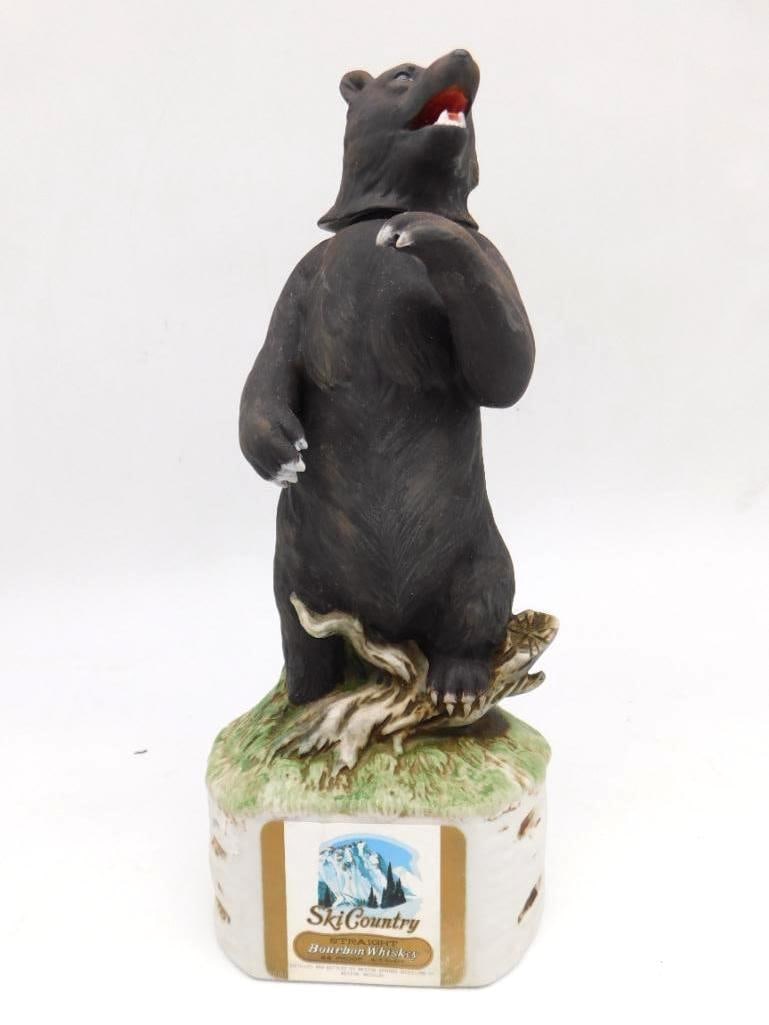Ski Country Standing Black Bear: A Ski Country porcelain decanter sculpted as a black bear standing upright upon a log and grass base, his mouth open. The hand-painted finish is detailed and the modeling commanding, a piece with