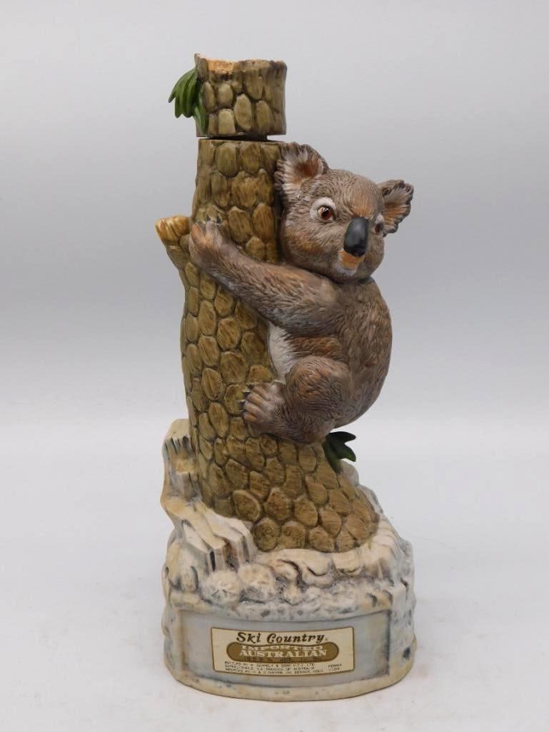 Ski Country Koala Bear on Eucalyptus: A well-turned Ski Country decanter modeled as a koala clambering up a eucalyptus trunk, a hind foot braced upon the rocky ledge below. The fur is finely tooled and softly painted, no small feat of