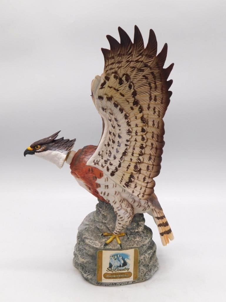 Ski Country Red-Tailed Hawk Porcelain: A Ski Country straight bourbon whiskey decanter in porcelain, modeled as a red-tailed hawk with wings spread wide above a rocky base, the Ski Country label in place. Measures approximately 13 inches a