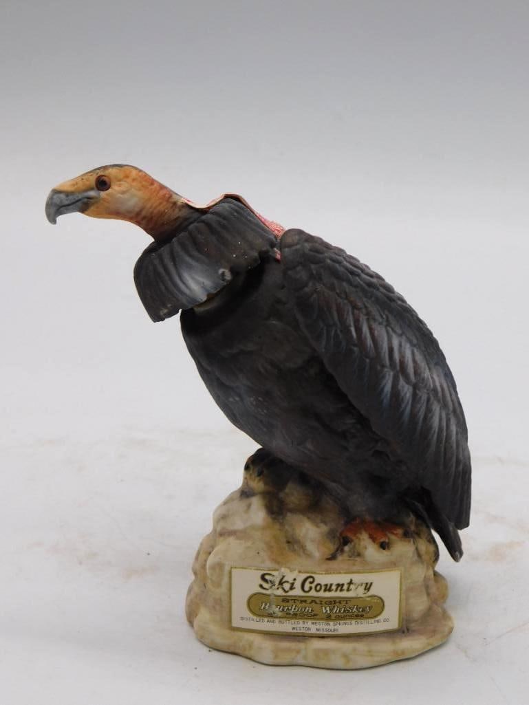 Ski Country Vulture Porcelain Decanter: A Ski Country porcelain decanter sculpted as a dark-plumed vulture, its bare head a startling red-orange, settled upon a rock base. An uncommon subject, and the modeler treated it with an earnest eye.