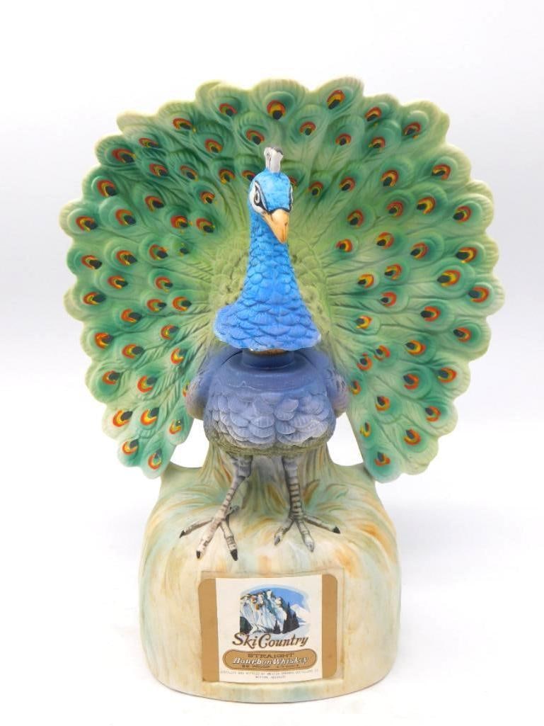 Ski Country Peacock in Full Display: A striking Ski Country decanter modeled as a peacock with its tail fanned in full display, every eye of the plumage painted in green, gold and deep blue. The crest and scaled neck are finely molded, n