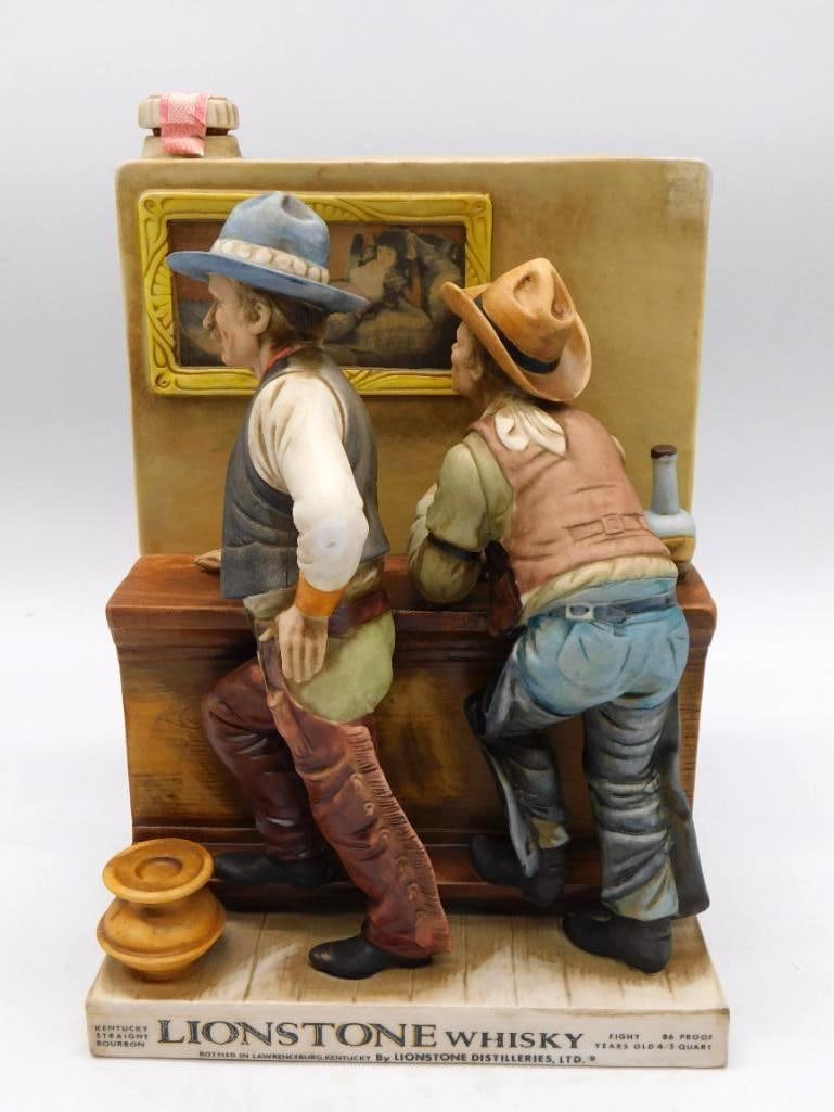 Lionstone Card Players Old West Decanter: A Lionstone Distilleries decanter sculpted with two cowboys bent over a hand of cards at a wooden table, a saloon backdrop behind them. Hand-painted ceramic upon a large rectangular base, and the scen