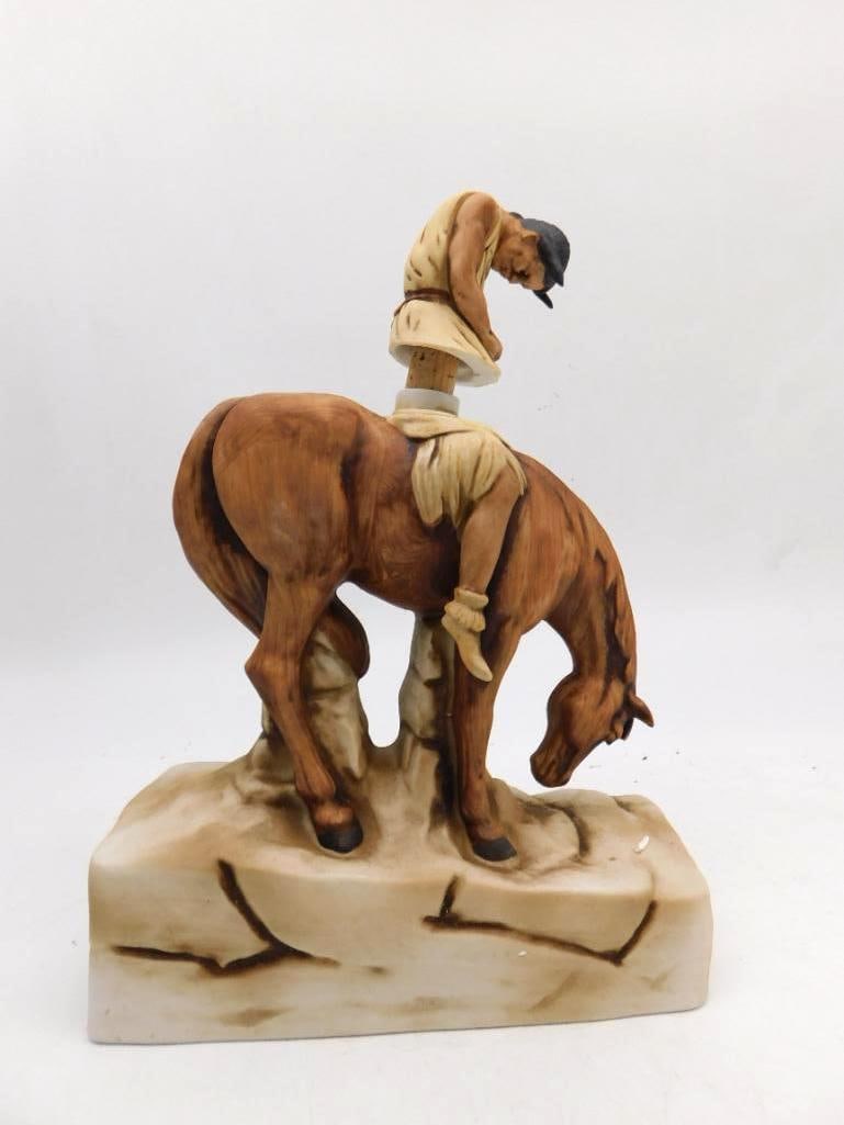 Ski Country Cowboy on Horse Decanter: A Ski Country Straight Bourbon Whiskey decanter in hand-painted porcelain, modeled as a weary cowboy slumped forward over his horse's neck. The sculptor caught the fatigue of a long day honestly.