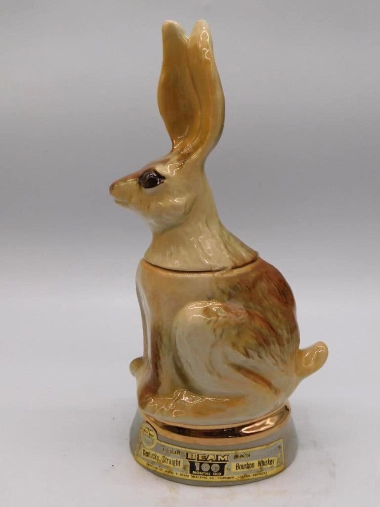 Jim Beam Rabbit Decanter: A cream-glazed Jim Beam ceramic decanter modeled as a seated rabbit, its long ears drawn together to form the pour spout, which is a clever turn by the mold-maker. Carries the Beam 100 Months Old