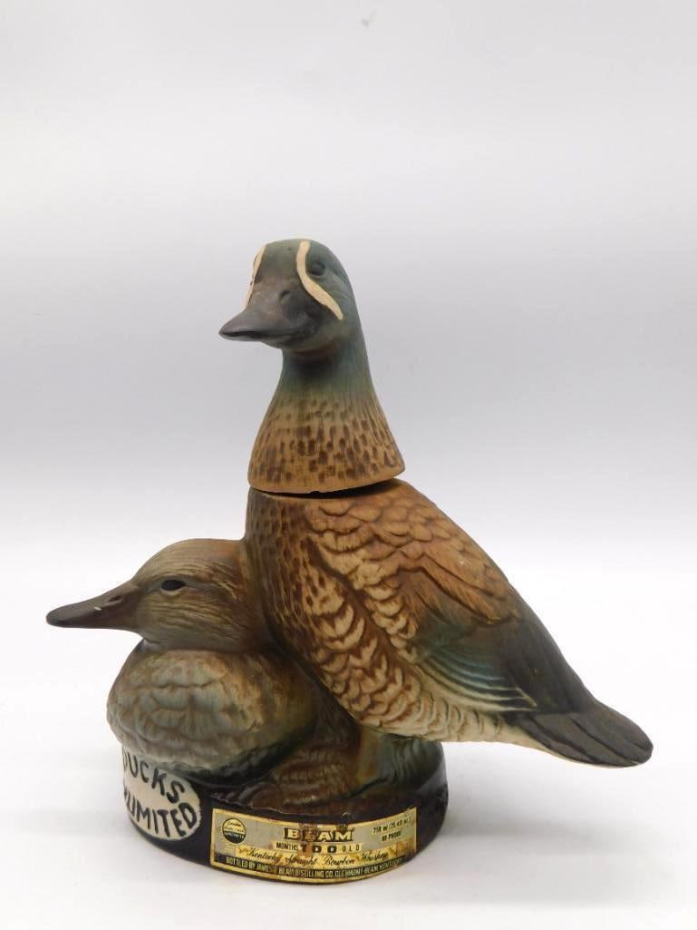 Jim Beam Ducks Unlimited Drake and Hen: A Jim Beam ceramic decanter modeled as a pair of ducks, drake and hen together, carrying the Ducks Unlimited medallion label and the Beam 100 Months Old Kentucky Straight Bourbon Whiskey back label.