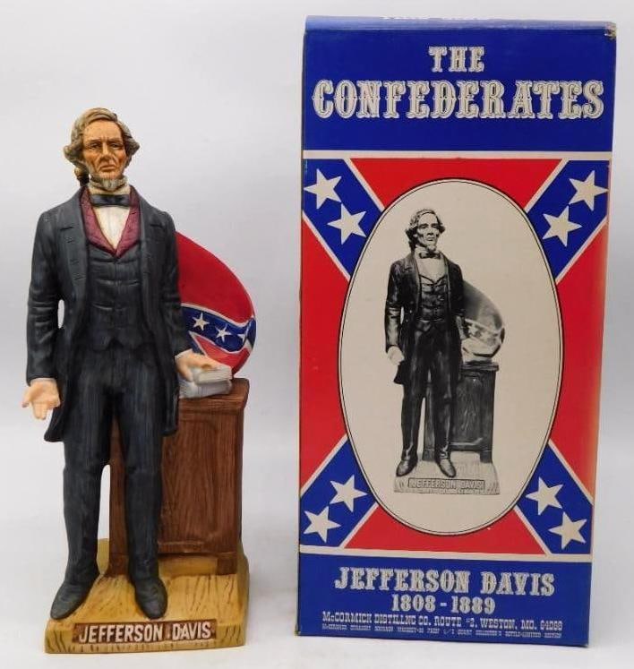 McCormick The Confederates Jefferson: A McCormick decanter from The Confederates series, modeled as Jefferson Davis standing beside a lectern with the furled battle flag at his shoulder. The painter did not stint on the detail of the froc