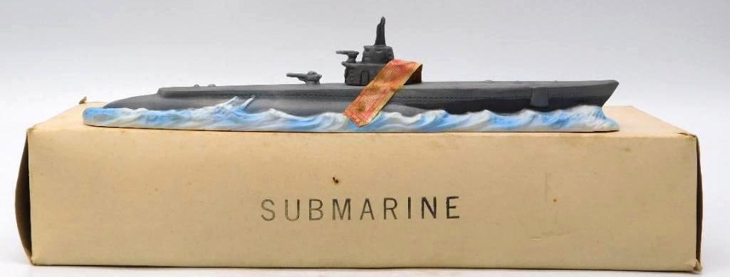 Naval Submarine Decanter with Conning: A long, low decanter cast as a naval submarine running on the surface, the conning tower, periscope and deck guns picked out in battleship gray above a white-capped blue sea. The modeling is