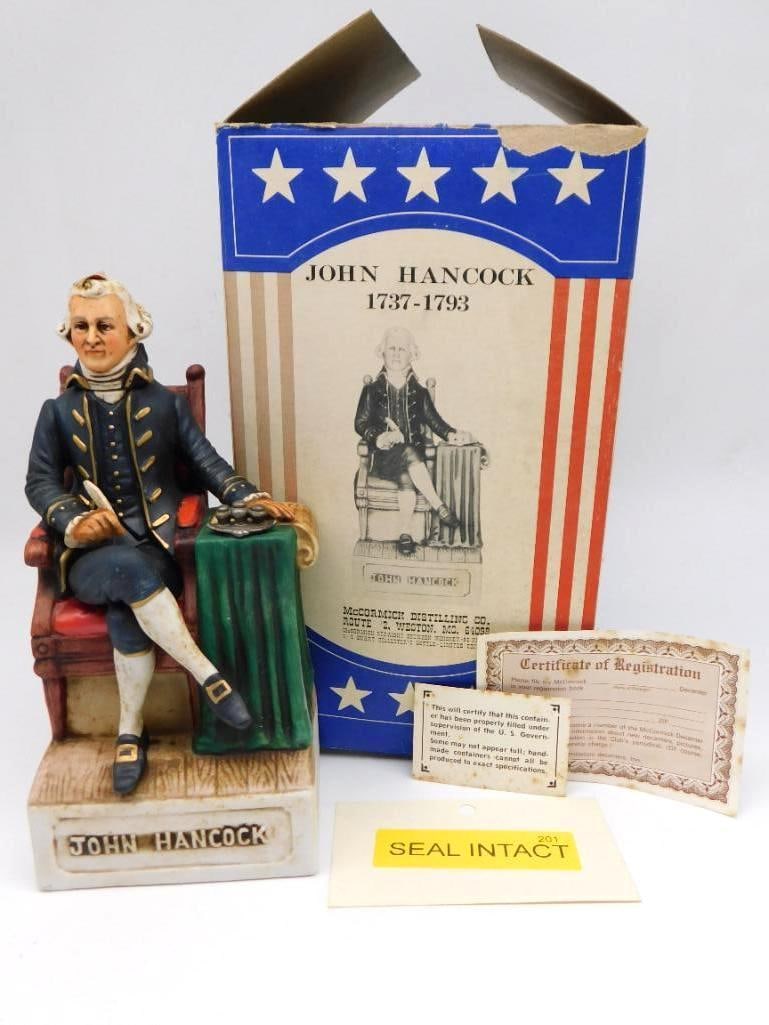 McCormick John Hancock Americana: A McCormick Americana Porcelain decanter modeled as John Hancock seated with quill pen in hand. Complete with its original illustrated box, registration certificate, and accompanying paperwork, which