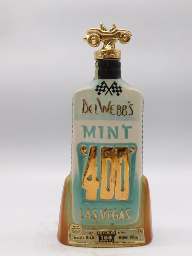 Jim Beam Del Webb's Mint 400 Desert: A Jim Beam Kentucky Straight Bourbon Whiskey decanter, 100 Months Old, marking the third annual Del Webb's Mint 400 Desert Rally at Las Vegas in March of 1970. A gold-tone dune buggy serves as the sto