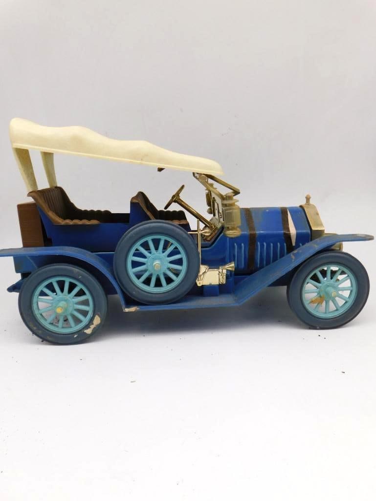 Antique Touring Car Ceramic Decanter: A ceramic decanter modeled after an early 1900s touring automobile, done in blue with a cream celluloid canopy top, gold-tone trim, and pale blue spoke wheels. Plastic accessory details finish the