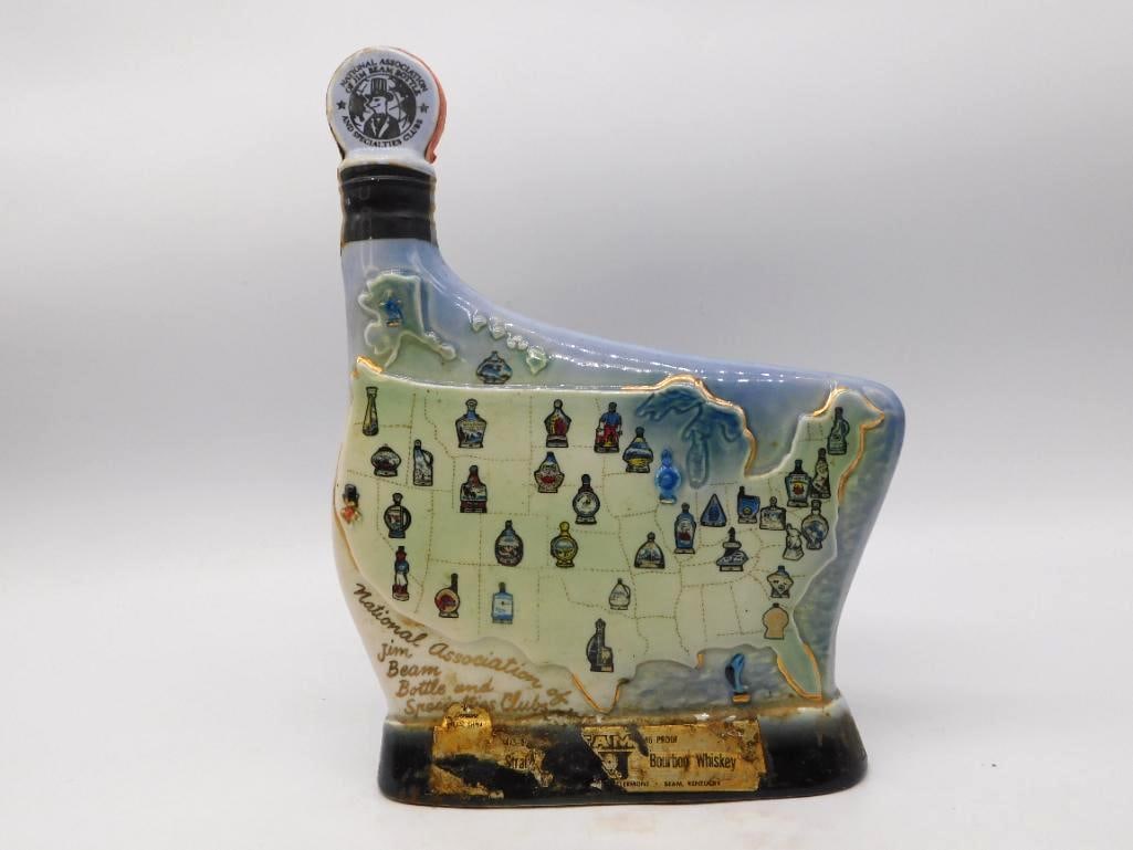 Jim Beam 1971 Natl Association: A Jim Beam club decanter shaped as the map of the United States, each state marked with a small painted decanter of its own. The reverse carries a raised scroll listing the 1971 affiliate clubs of the
