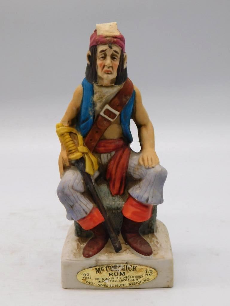 McCormick Rum Pirate Decanter, Half Pint: A small-format McCormick Rum decanter modeled as a seated pirate with cutlass in hand, a rakish character in half-pint size. Bottled for West Indies Bottlers of Weston, Missouri. See photos for exact 