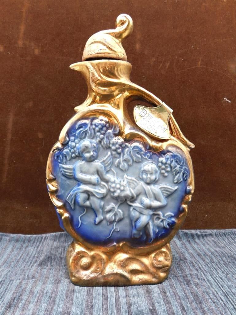 Jim Beam Cherub and Grape Regal China: A Jim Beam Kentucky Straight Bourbon decanter in Regal China, gold and cobalt, with a cherub and grape motif in relief. Handsome enough to earn a place on any sideboard. Marked 100 months old. See