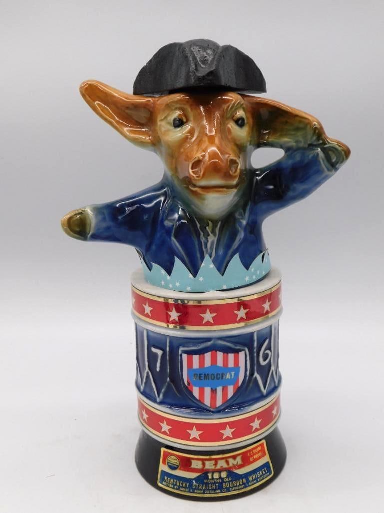 Jim Beam 1976 Bicentennial Democrat: A Jim Beam Bicentennial decanter of 1976, its Democrat donkey standing in a patriot hat atop a red, white, and blue drum base lettered 76 and Democrat. Ceramic, marked 100 months old and 80 proof,