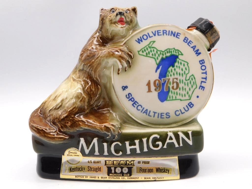 Jim Beam Michigan Wolverine Bottle Club: A Jim Beam Regal China decanter with a wolverine climbing beside a Michigan state medallion, marked for the Wolverine Beam Bottle and Specialties Club, 1975. A lively bit of modeling, and the state