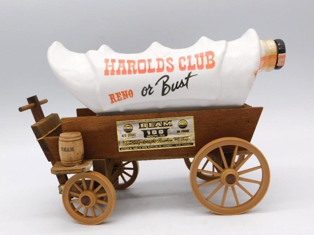 Jim Beam Harolds Club Reno or Bust: A Jim Beam Kentucky Straight Bourbon decanter in the form of a covered wagon, advertising Harolds Club of Reno with the old cry of Reno or Bust. The whiskey bottle rides in the wagon bed upon a wood