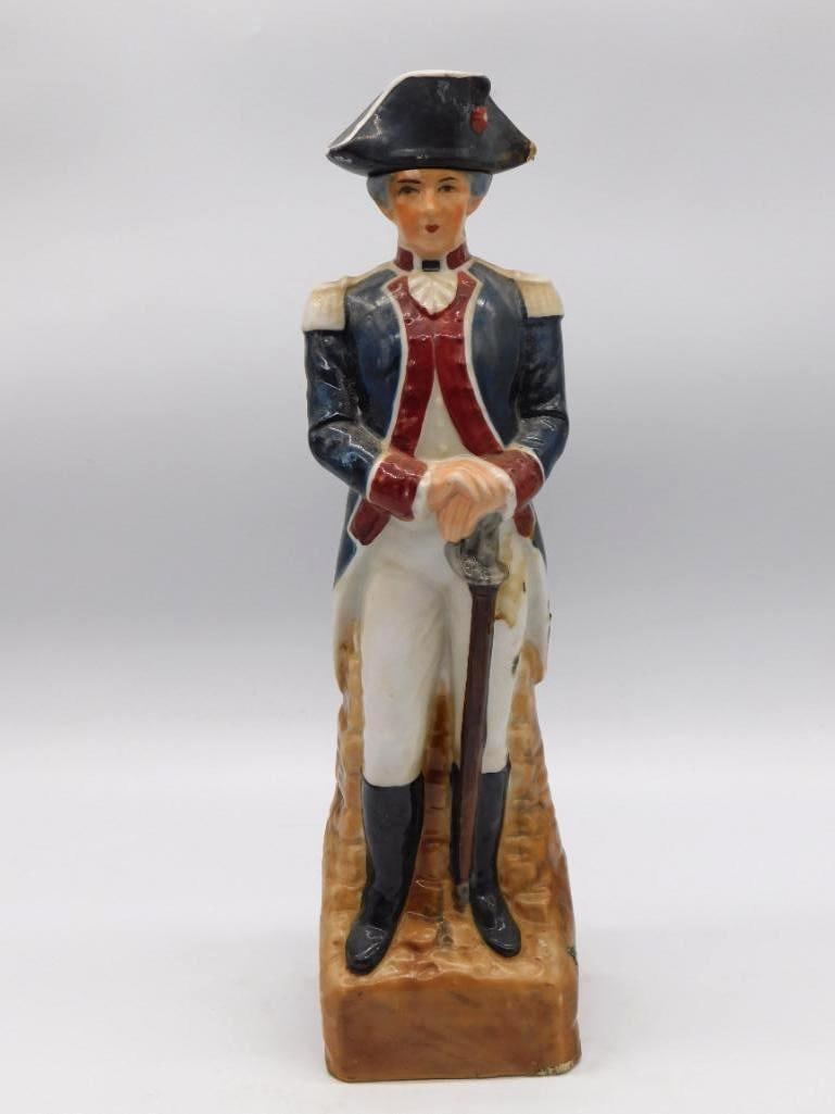Continental Army Revolutionary War: A ceramic decanter modeled as a Continental Army officer in a blue coat and tricorn hat, his sword held at his side. Unbranded as to maker. A resolute figure standing approximately 12 inches tall as