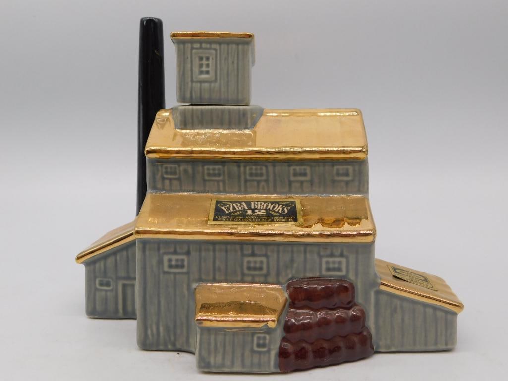 Ceramic Hometown Building Decanter: A hand-painted ceramic decanter modeled as a small gray hometown building with a brown chimney and rooftop antenna, in the style of a landmark or firehouse series decanter. No maker's mark is visible