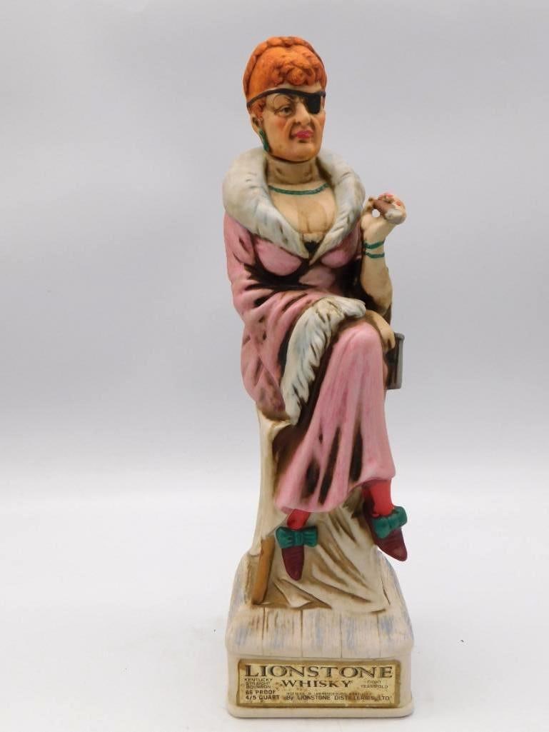 Lionstone Madame Decanter, 1870-1890: A bisque porcelain decanter modeled as a Victorian lady in a fur-trimmed pink gown, handsomely turned and titled Madame 1870-1890 on the base plaque. Marked Lionstone Whiskey. Approximately 13 inches 