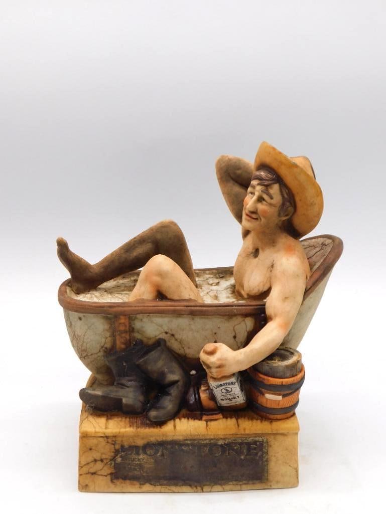 Lionstone Cowboy in Bathtub Decanter: A novelty ceramic decanter from Lionstone showing a cowboy at his ease in a claw-foot bathtub, hat and boots set aside and a miniature bottle of Lionstone Whiskey in hand. A genial bit of Old West hum