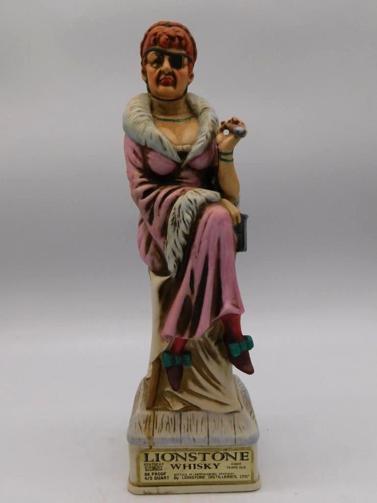Lionstone Old West Series Madame Ceramic: A Lionstone Distilleries decanter from the Old West series titled Madame, portraying a bordello proprietress in a pink dress with a knowing air. The base carries a historical narrative plaque reading 