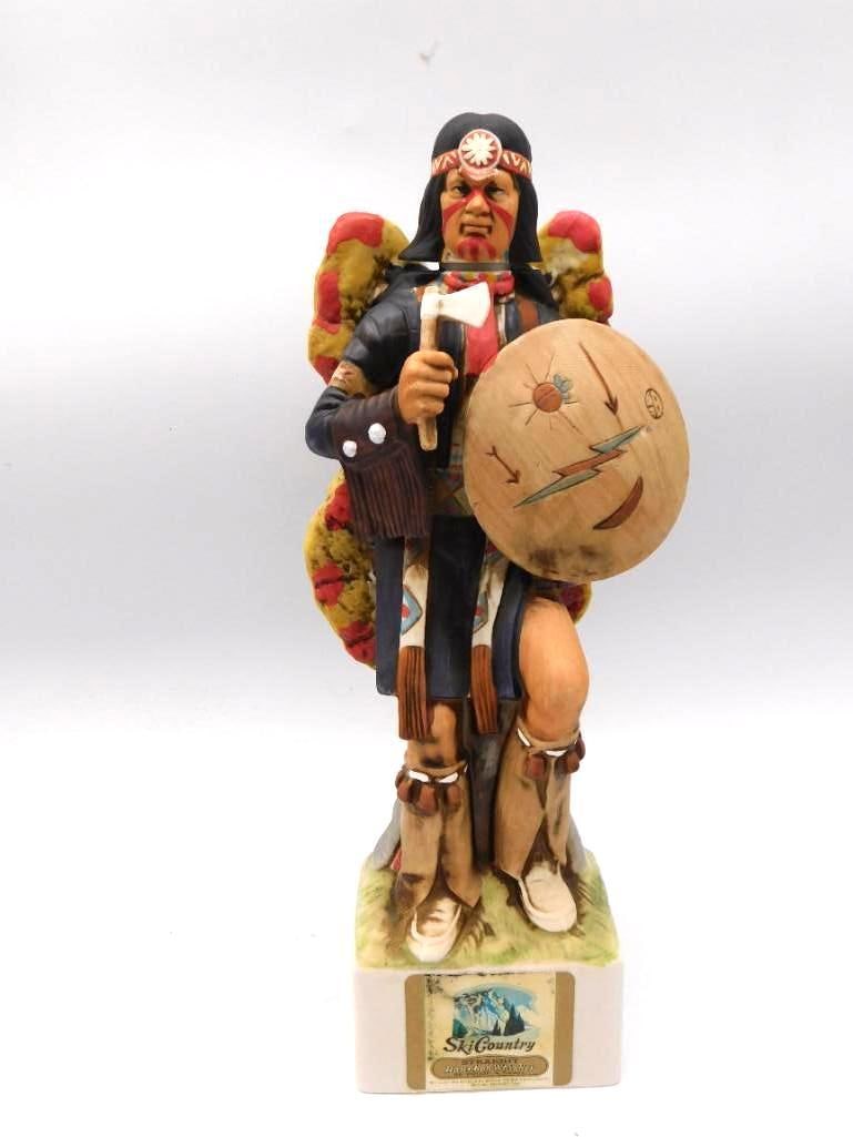 Ski Country Sun Torment Shield Dancer: A Ski Country Bourbon Whiskey ceramic decanter rendered as a Native American shield dancer performing the Sun Torment ceremony, his beaded and feathered war shield held high. The modeling is spirited,