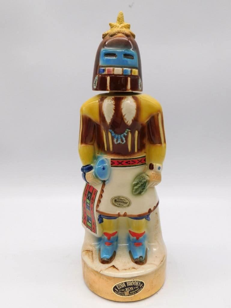 Ezra Brooks Heritage China Kachina: An Ezra Brooks decanter from the Heritage China line, sculpted after a Southwestern Kachina in ceremonial dress. The yellow, blue, and red paintwork is handsomely done, down to the fringed sash.