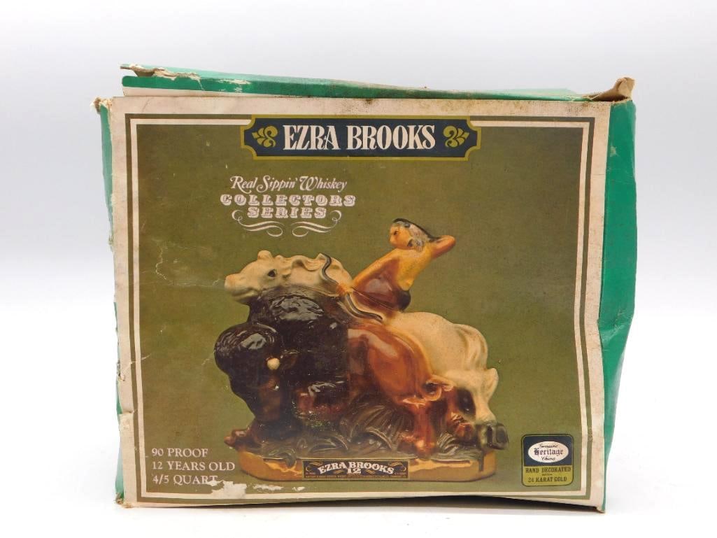 Ezra Brooks Buffalo with Native American: An Ezra Brooks ceramic decanter modeled as a bison bearing a Native American rider, hand-painted in brown, black and cream upon a gold base. Marked Real Sippin' Whiskey Collectors Series, 12 Years