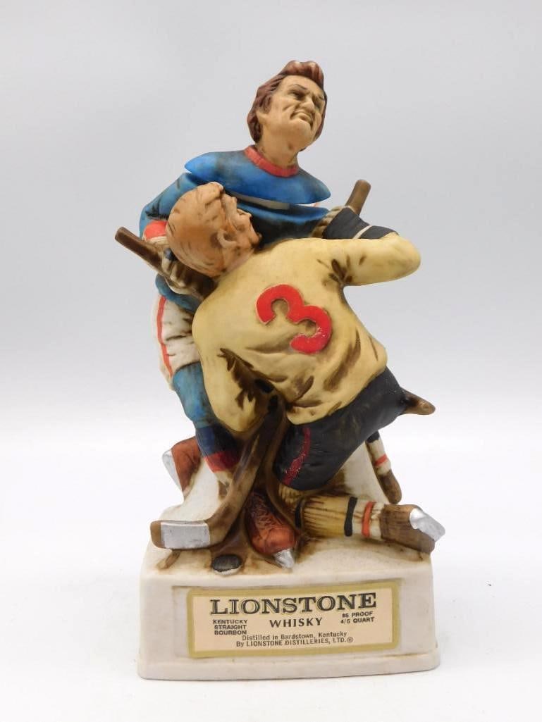 Lionstone Ice Hockey Players Decanter: A spirited Lionstone decanter in bisque porcelain, two hockey players caught in collision, one of them in jersey number 3. The sculptor rendered the scrape with a shrewd eye for motion. Approximately 
