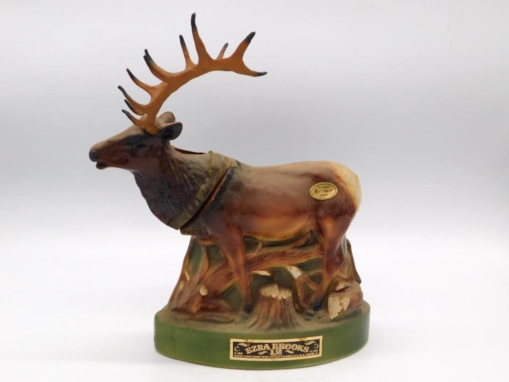 Ezra Brooks Heritage Bull Elk Ceramic: An Ezra Brooks "Heritage" Kentucky Straight Bourbon Whiskey decanter sculpted as a standing bull elk with a broad rack of antlers, set upon a green base marked "Ezra Brooks 12." A stately animal
