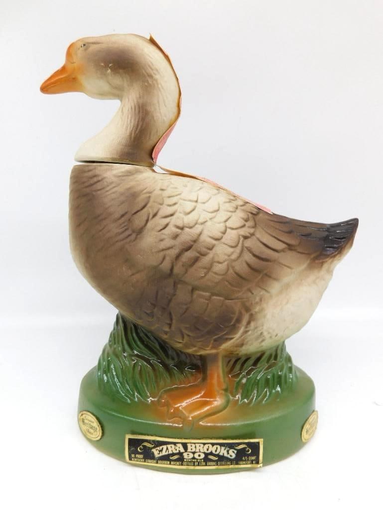 Ezra Brooks Heritage China Goose: An Ezra Brooks Heritage China decanter modeled as a standing goose upon a green grassy base. Stands approximately 9.5 inches tall. The underside is marked Heritage China 1974 R.H.-51 Ezra Brooks. See