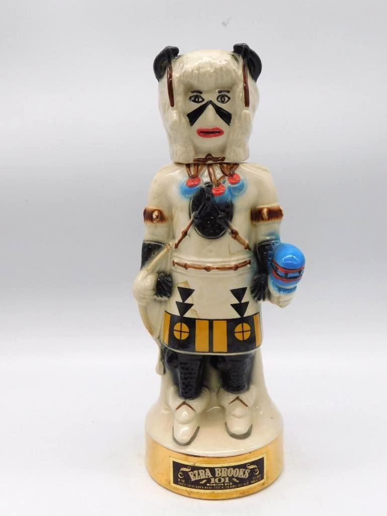 Ezra Brooks White Kachina Ceramic: An Ezra Brooks ceramic decanter modeled after a Southwestern Kachina, rendered in cream and black with turquoise-blue accents. A tall and dignified piece, the mold-work crisp about the headdress.