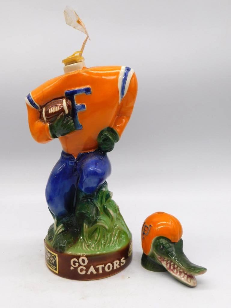 Florida Gators Football Player Decanter: A ceramic whiskey decanter sculpted as a University of Florida Gators football player in an orange and blue jersey, squared up and ready for the snap. The detachable stopper takes the form of an