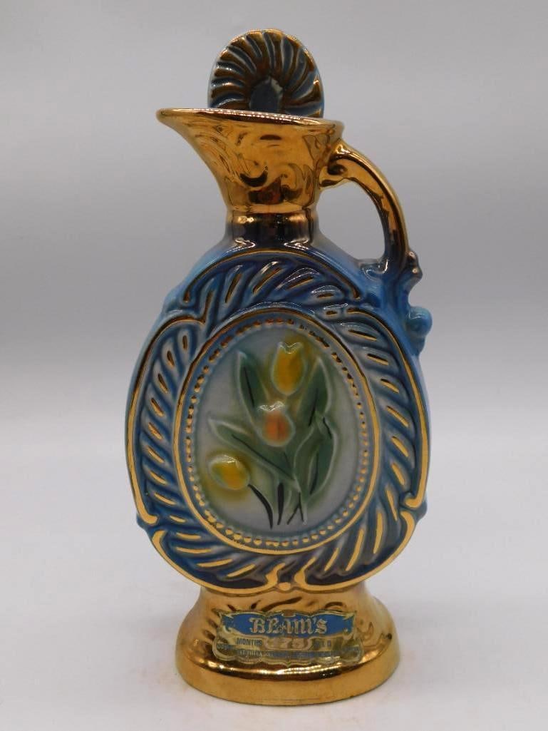 Jim Beam Bing Crosby Pro-Am Natl Golf: A Jim Beam porcelain decanter in blue and gold commemorating the 33rd Bing Crosby Pro-Am National golf tournament. The scalloped shell-form body and gilt handle make an ornate showing. Approximately 8