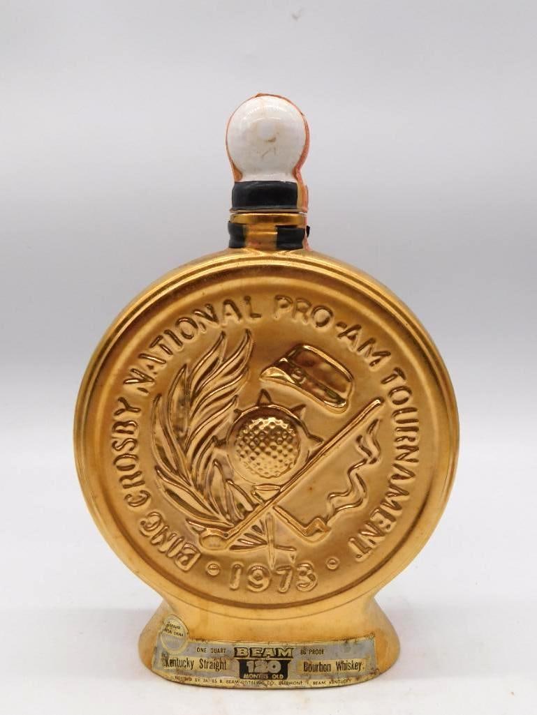 Jim Beam Bing Crosby Natl Pro-Am 1973: A Jim Beam Regal China decanter finished throughout in gold, struck for the 1973 Bing Crosby National Pro-Am golf tournament and raised with a golf ball, club, and flag design. The Kentucky Straight B