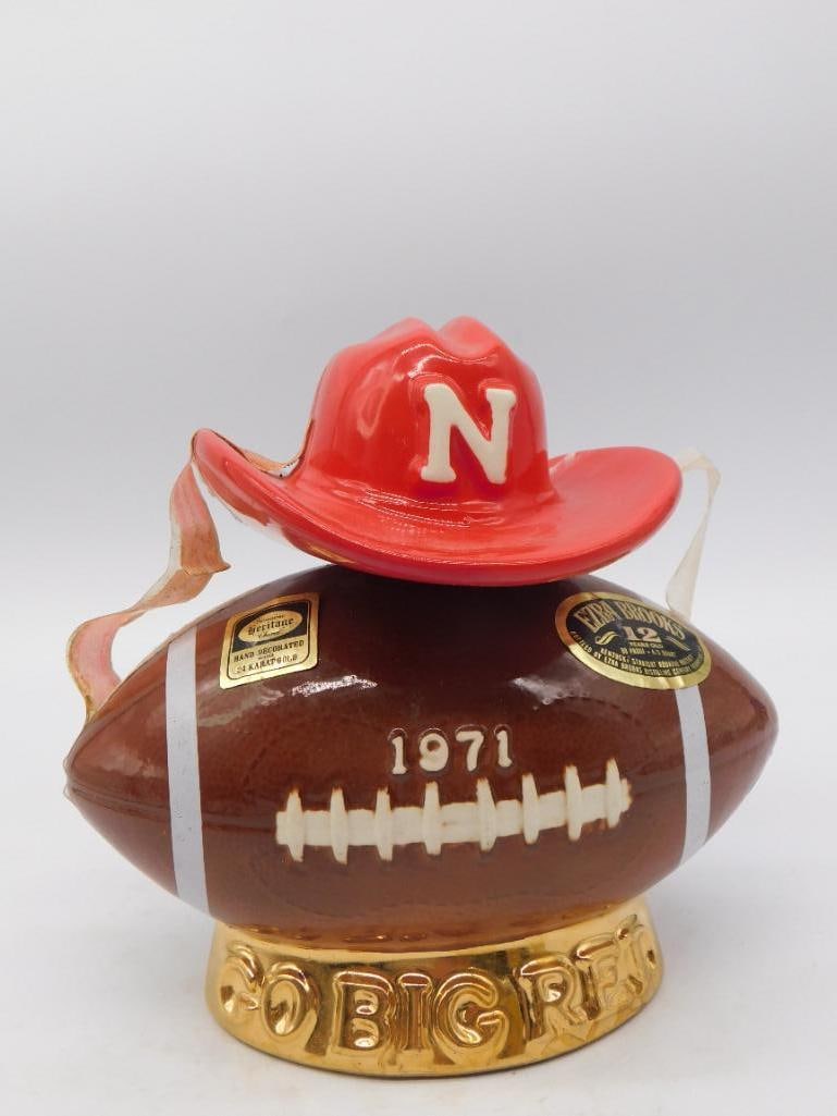 Ezra Brooks Nebraska Cornhuskers: An Ezra Brooks decanter shaped as a football embossed "1971," topped with a red cowboy hat stopper bearing the Nebraska Cornhuskers "N," celebrating the Go Big Red football program. See photos for exa