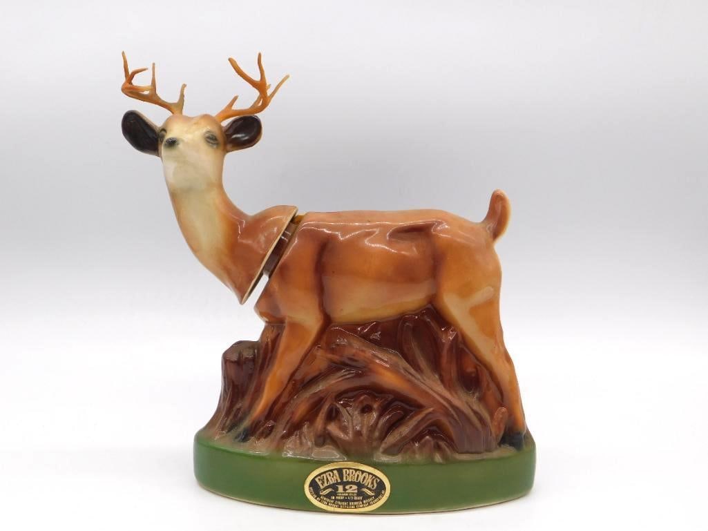Ezra Brooks Whitetail Buck Ceramic: An Ezra Brooks 12 Kentucky Straight Bourbon Whiskey decanter sculpted as a standing whitetail buck in full antler upon a green base. Stands approximately 11 inches tall. Stated frankly: some