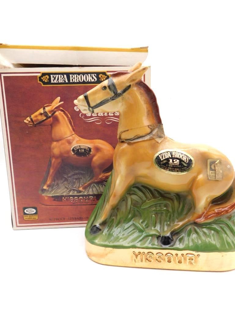 Ezra Brooks Missouri Mule Horse Decanter: An Ezra Brooks ceramic decanter modeled as a standing horse, the base titled Missouri, with gold-tone hardware accents. Marked 12 Years Old and offered with its original illustrated box. An agreeable