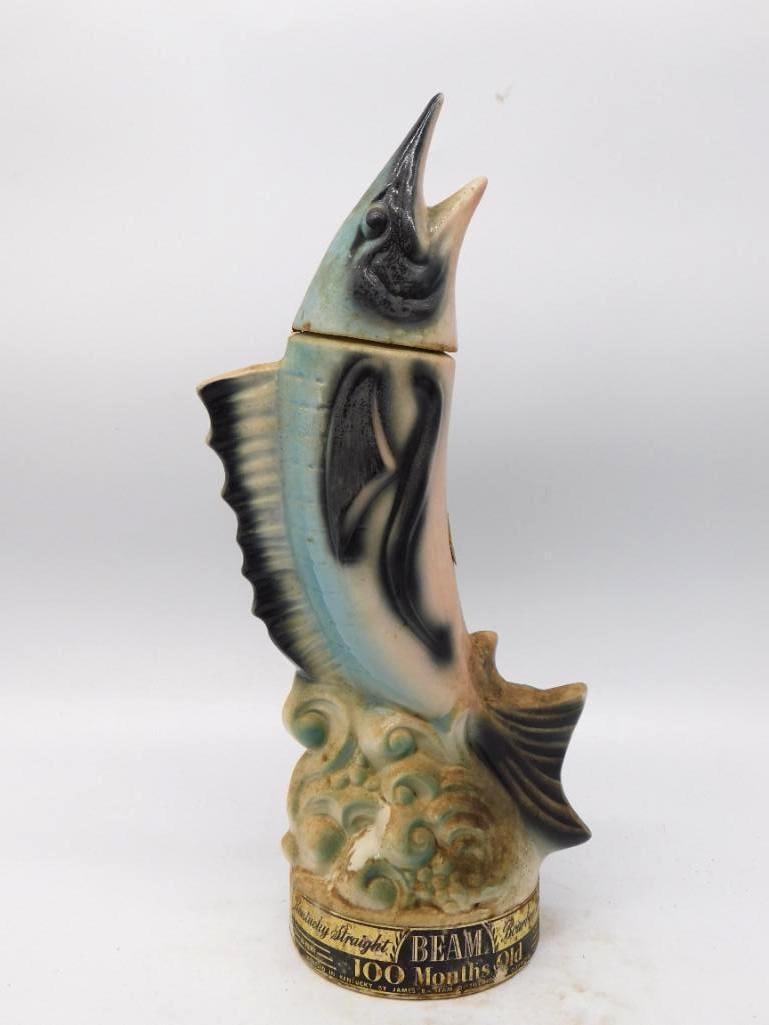 Jim Beam Sailfish Regal China Decanter: A spirited Jim Beam decanter shaped as a sailfish breaking clear of a curling wave, bill up and fins spread wide. The airbrushed blues and blacks along the flank are handsomely done, and the foaming w