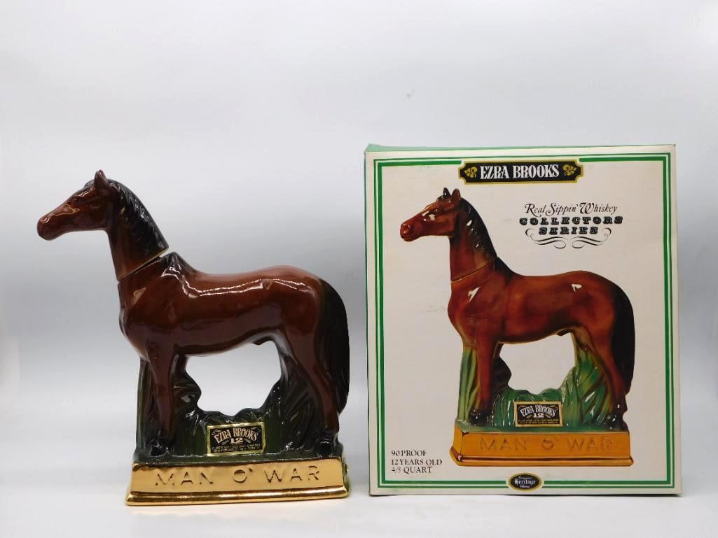 Ezra Brooks Collectors Series Man O' War: A handsome Ezra Brooks decanter modeled as the thoroughbred Man O' War standing at ease in the grass, the chestnut glaze deep and even and the head forming the stopper. The gold-tone plinth is lettere