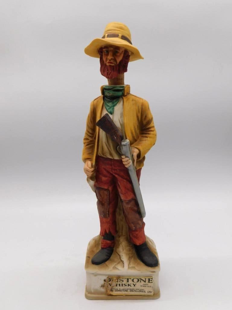 Western Sodbuster Homestead Law: A ceramic decanter sculpted as a pioneer Sodbuster in period dress with rifle in hand, a homesteader's portrait with a resolute set to him. The base carries a printed plaque describing the Homestead L