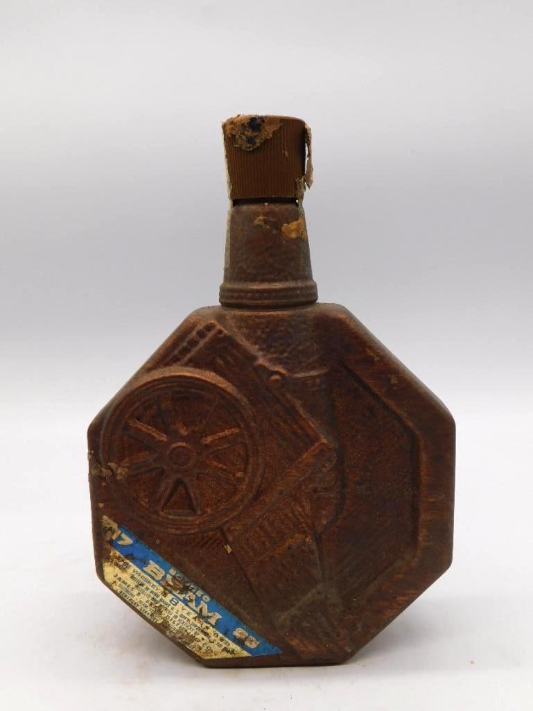 Jim Beam Regal China Wagon Wheel Motif: A Jim Beam Regal China decanter of octagonal form, its sides raised with a wagon wheel and wood-grain motif under a rustic brown glaze. The surface shows notable oxidation and staining with honest