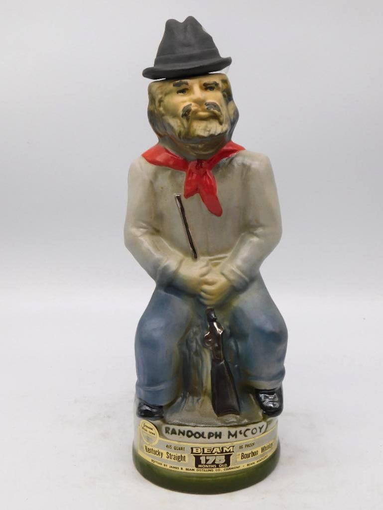 Jim Beam Randolph McCoy 1825-1915: A Jim Beam decanter modeled as Randolph McCoy, the old feudist seated with a shotgun across his knees, slouch hat low and red kerchief at his throat. The sculptor caught a shrewd, weathered face and