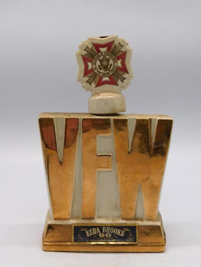 Jim Beam VFW Veterans of Foreign Wars: A cream and gold Jim Beam ceramic decanter shaped as a trophy, commemorating the Veterans of Foreign Wars, Travel Germany chapter, and capped with an enamel VFW medal stopper. The Kentucky Straight