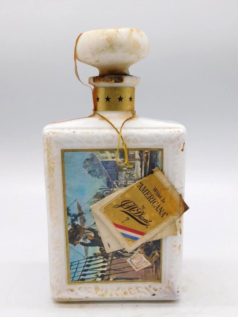 J.W. Dant Americana Collection Great: A J.W. Dant flask decanter from the Americana Collection, Great Moments in History, molded with an eagle and star device and carrying a lithographed harbor scene, its stopper banded in gold stars.