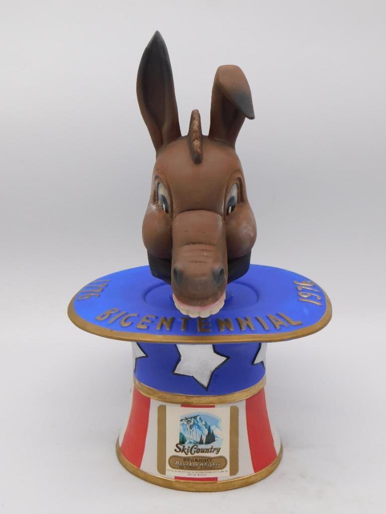 Bicentennial Donkey Decanter, 1776-1976: A hand-painted ceramic decanter modeled as a donkey bust rising from a red-white-and-blue star-and-stripe medallion base inscribed "Bicentennial 1976," marking America's 200th anniversary with the