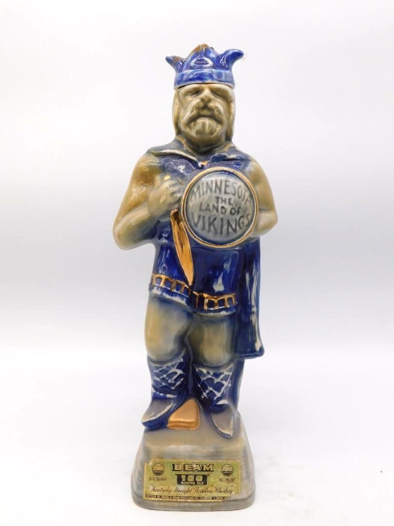Jim Beam Minnesota Land of Vikings: A Jim Beam Regal China decanter modeled as a Norse warrior in crested helm and blue cloak, holding a shield lettered Minnesota, the Land of Vikings. The reverse carries the Kensington Runestone dated 