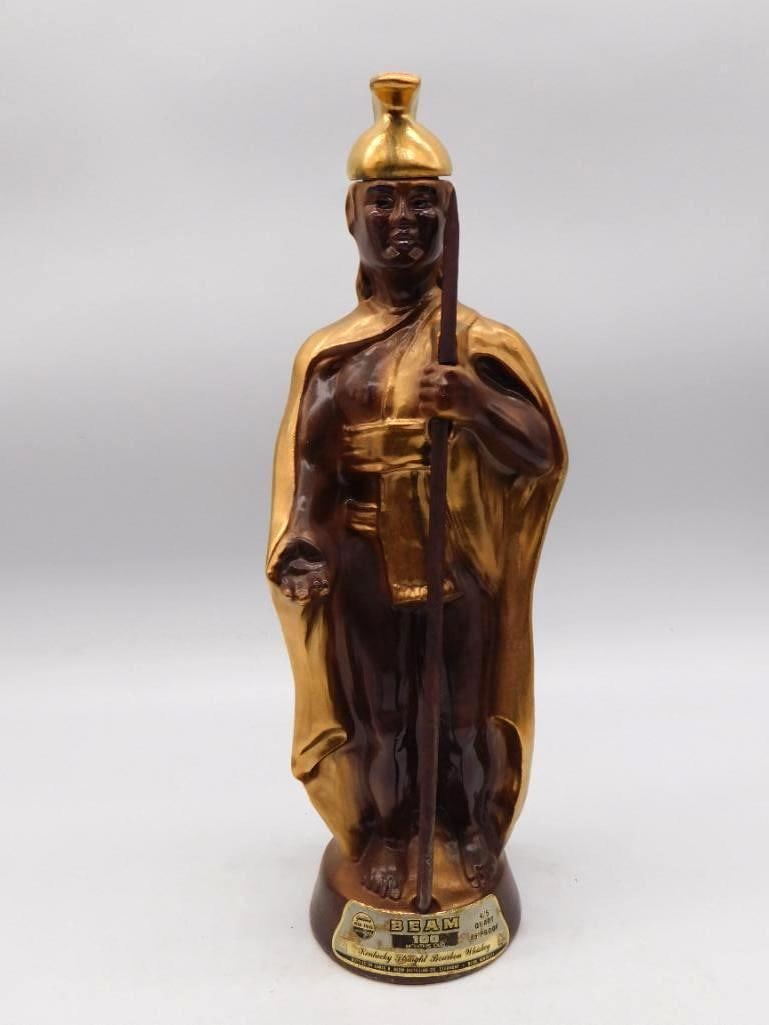 Jim Beam King Kamehameha Hawaii Decanter: A stately Jim Beam decanter modeled as King Kamehameha of Hawaii, cloaked and helmeted, a spear held at his side. The gold luster on the cloak and helmet has held its brightness admirably, and the