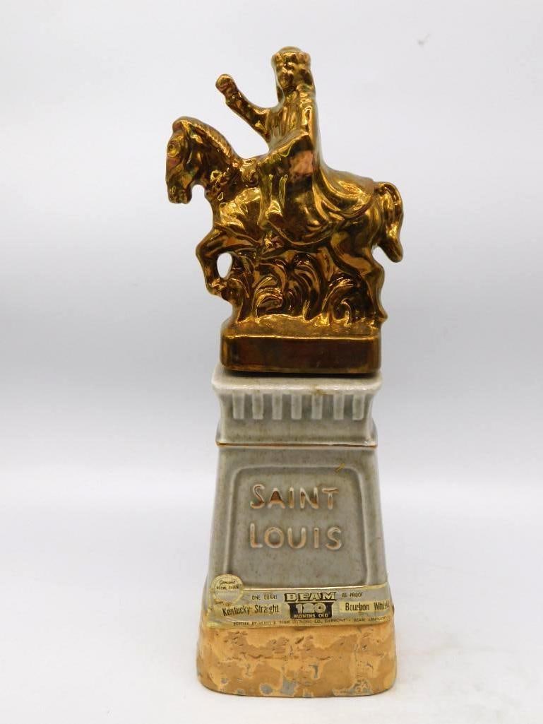 Jim Beam Saint Louis Equestrian Statue: A Jim Beam decanter after the equestrian statue of Saint Louis, the mounted king cast in bright gold luster upon a gray plinth lettered SAINT LOUIS, with a horseshoe modeled on the reverse. Stands app