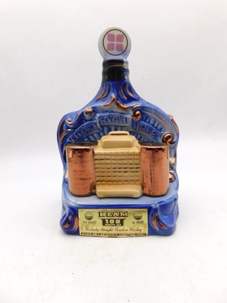 Jim Beam Regency Hyatt House Decanter: A Jim Beam Regal China decanter marking the Regency Hyatt House, in cobalt blue with copper-tone accent bands. The original gold Beam 100 Months Old neck label remains. Good vintage condition. See pho